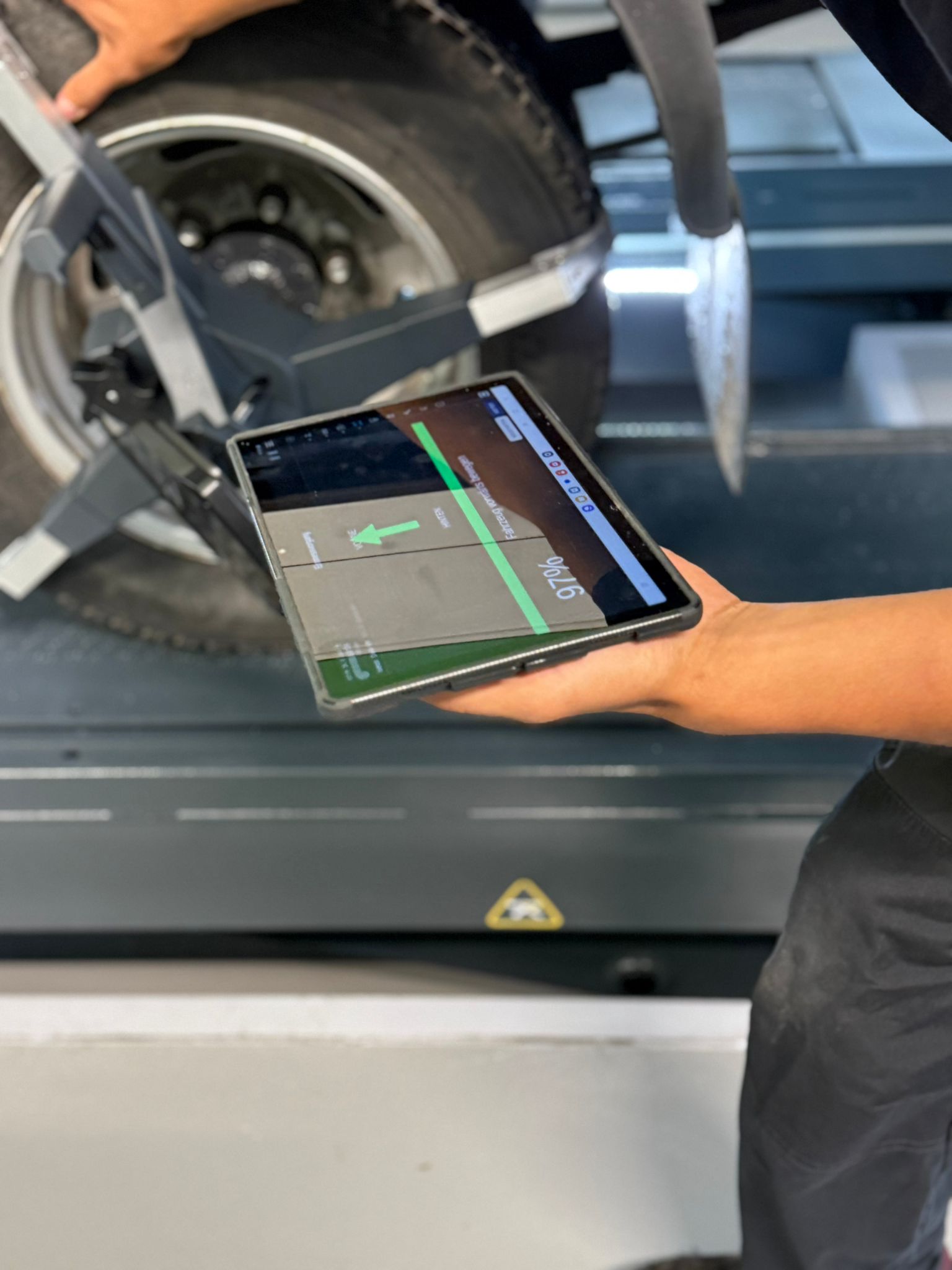 Live-Achsvermessung an einem Transporter — Techniker prüft die Messung am Tablet